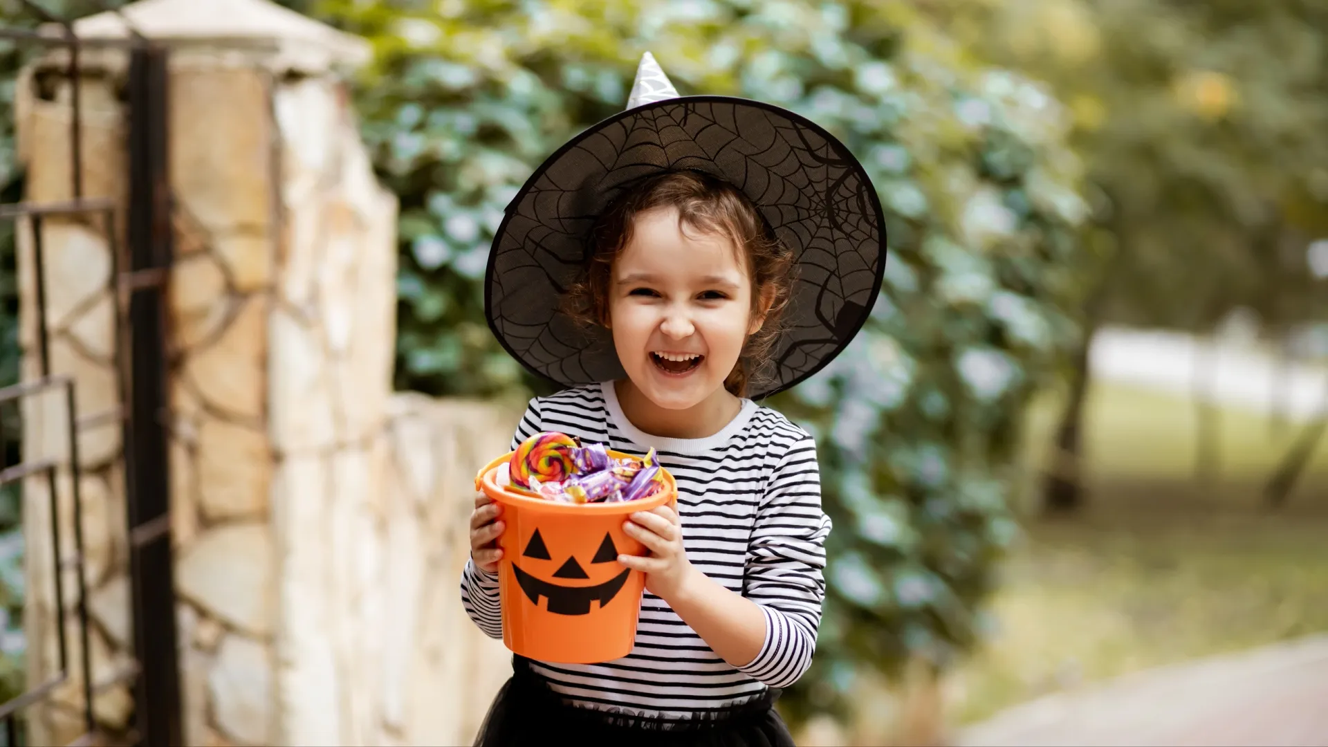 Юная «ведьмочка» довольна «уловом» на Хеллоуин. Фото: Zulfiska / Shutterstock / Fotodom