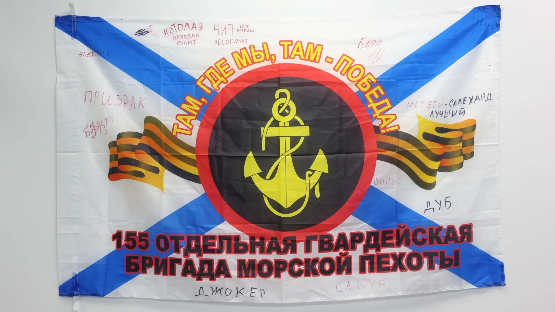 Флаг морской пехоты из зоны СВО с подписями ямальских бойцов. Фото: Андрей Ткачёв / «Ямал-Медиа»