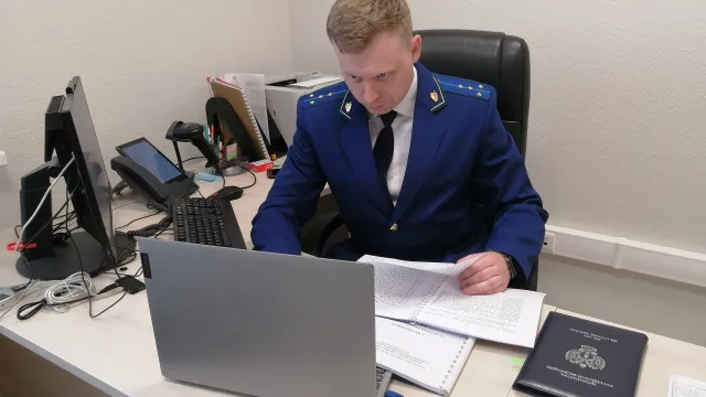 Прокурор работает с изъятой документацией. Фото: Лев Гуляев / КРАСНЫЙ СЕВЕР