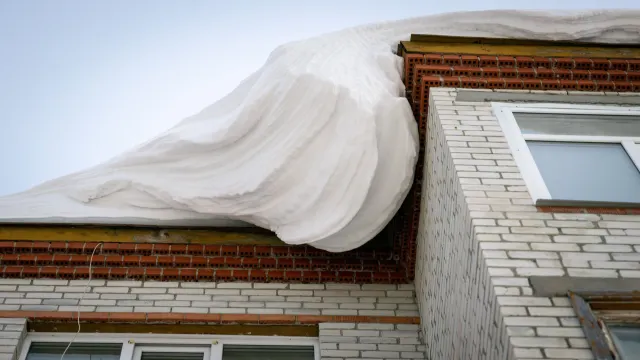 На Ямале переменчивая погода привела к скоплению снега на крышах домов. Фото: Фёдор Воронов / "Ямал-Медиа"